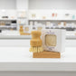 Wooden dish brush and packaging on a white surface with blurred shelves in the background