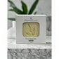 Mamasuds face wash bar packaging on a marble surface with a plant in the background