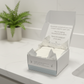 Box of MamaSuds toilet bombs on a bathroom counter with a blurred green plant in the background.